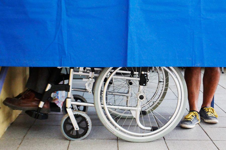 Persona en silla de ruedas votando. Estipendio.