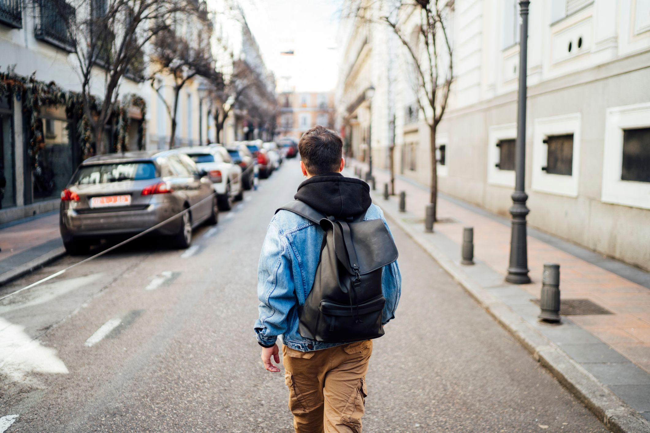 Un joven con una mochila por una calle de Madrid. 