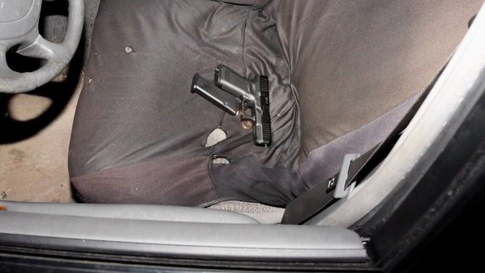 La policía publicó imágenes de una pistola en un asiento de automóvil.
