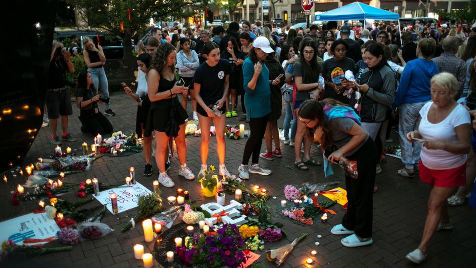 Residentes dejan velas y flores en el lugar de los hechos violentos.
