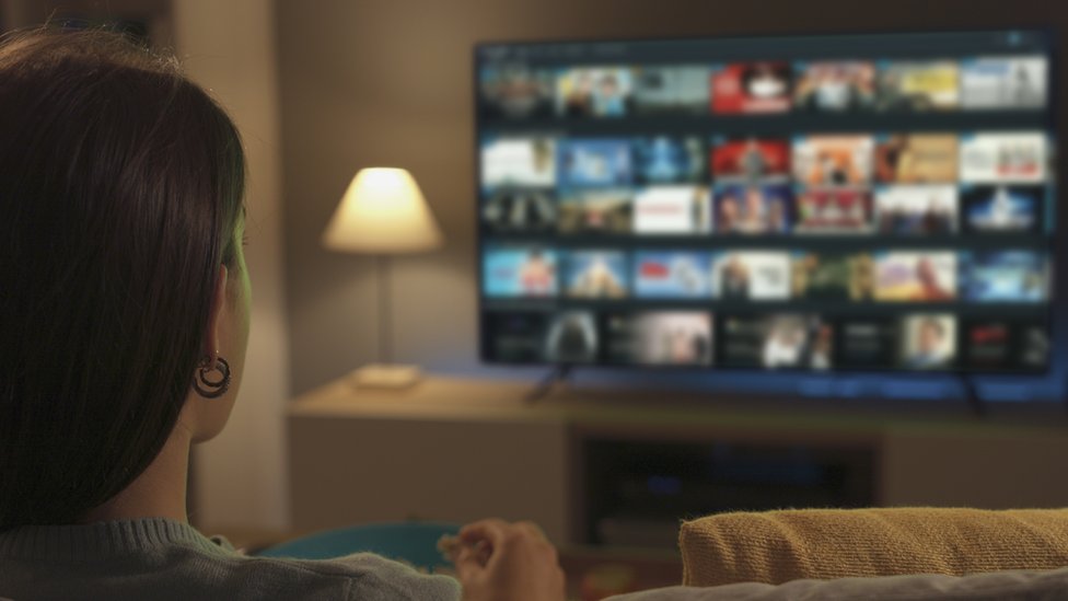 Una mujer ve una plataforma de streaming en su televisión.