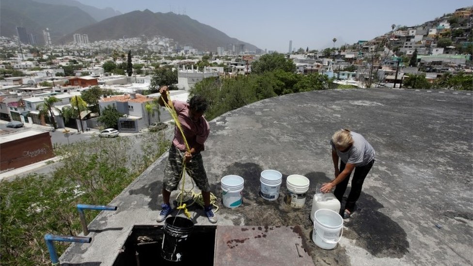 Personas extran agua de un pozo