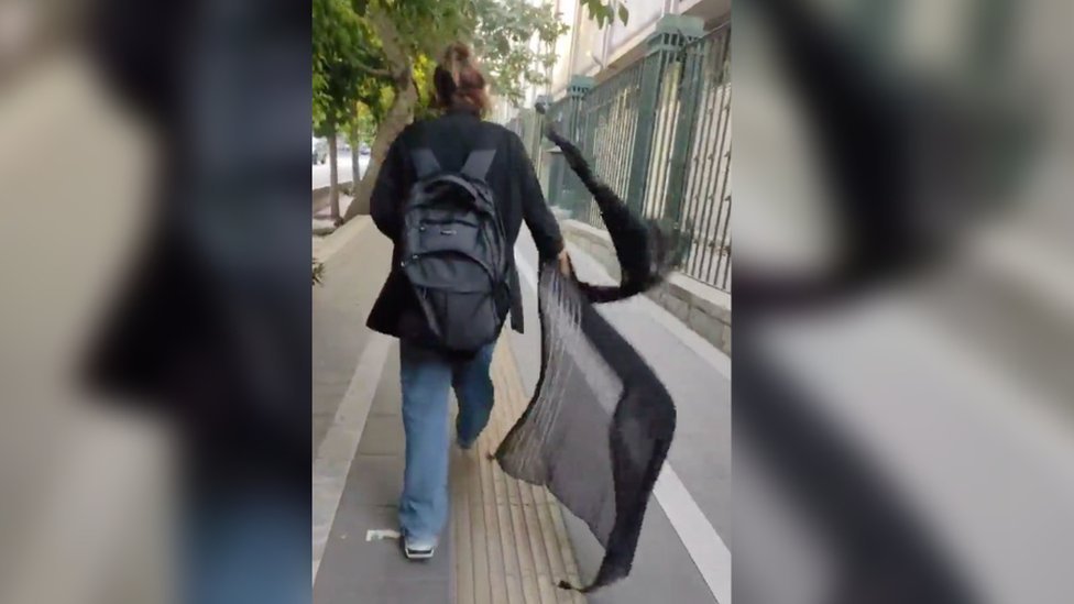 Una mujer se quita el hiyab en la calle
