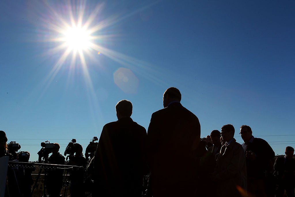 Imagen de un sol brillante y siluetas de personas.