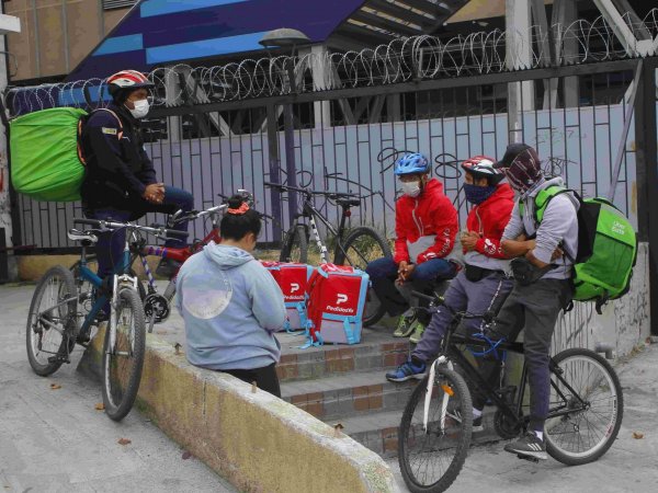 Trabajadores de plataformas de delivery sentados en la calle