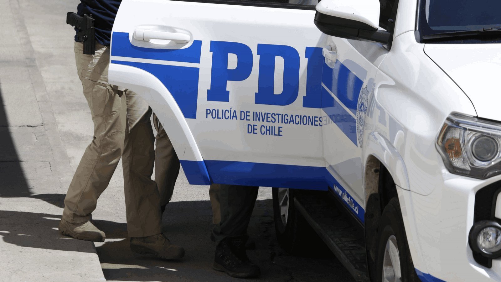 PDI traslada a un detenido a bordo de una camioneta institucional
