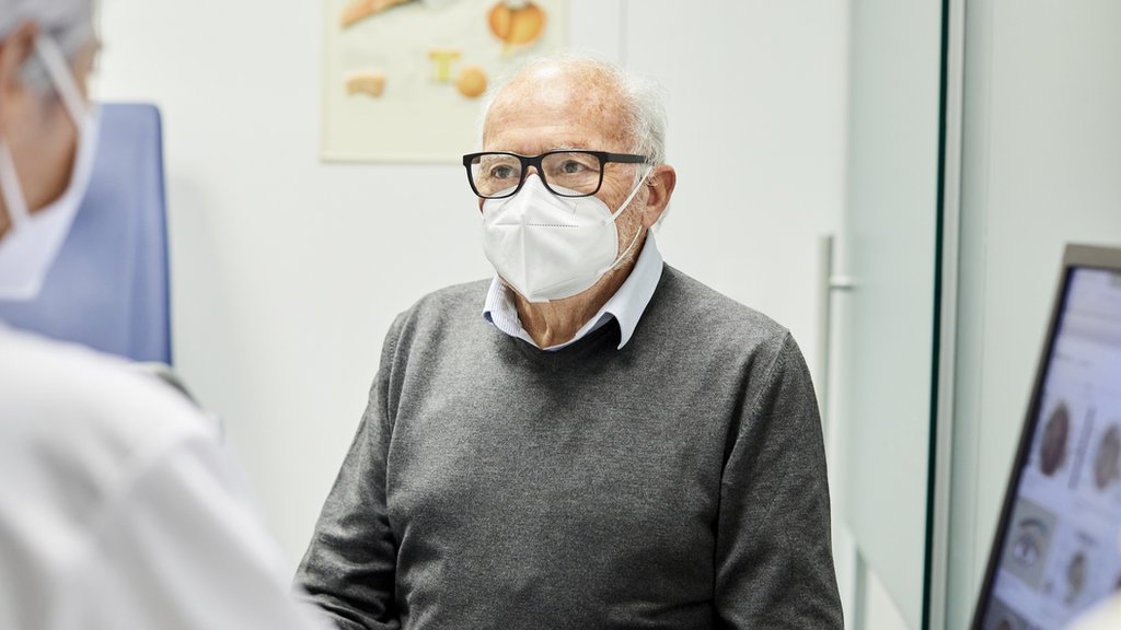 Un anciano usando una mascarilla