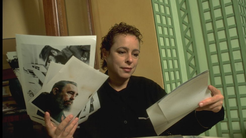 Alina Fernández sostiene varios papeles y la foto de su padre, Fidel Castro.