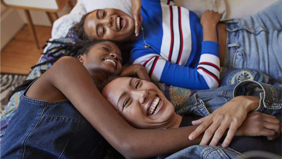 Tres mujeres en una cama.