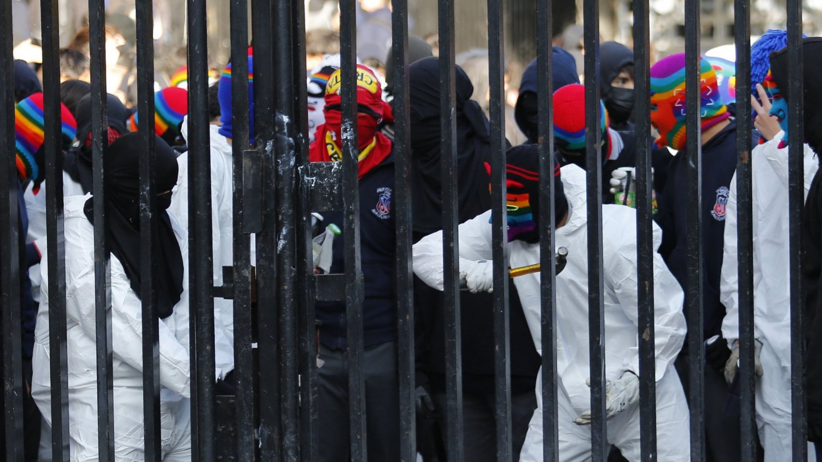 Estudiantes del Instituto Nacional vestidos con overoles blancos en medio de manifestaciones