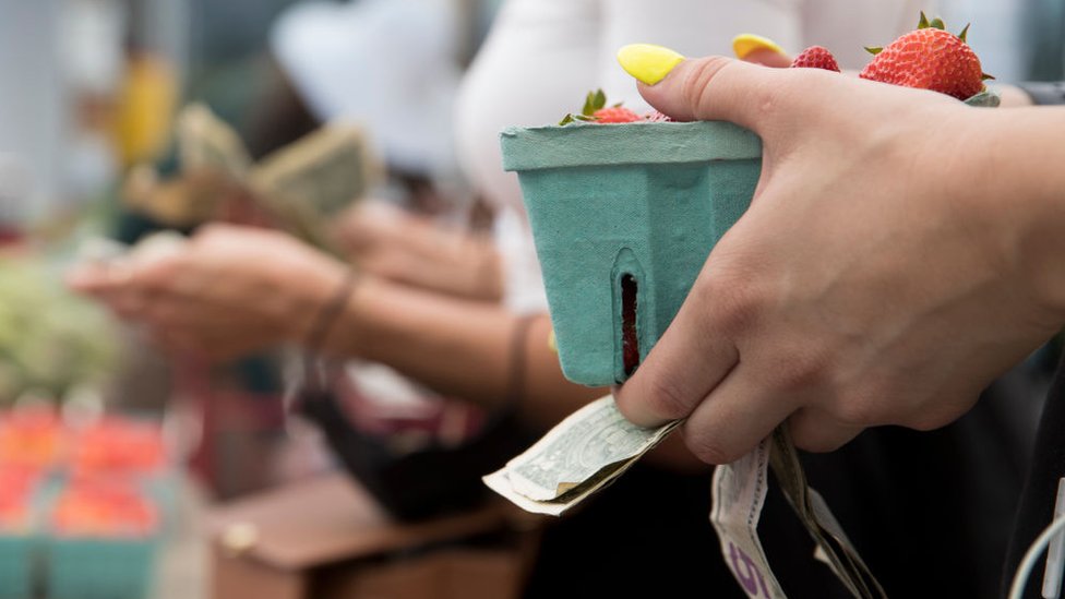 cONSUMIDORA CON CAJA DE FRESAS EN LA MANO