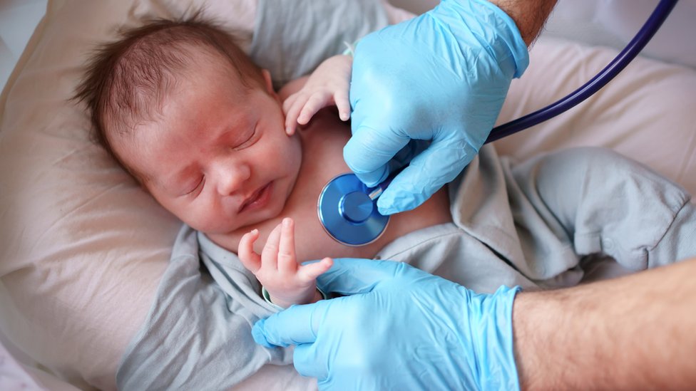 Bebé siendo examinado por un médico