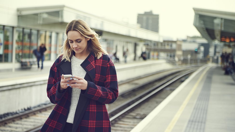 Mujer mirando su teléfono celular.