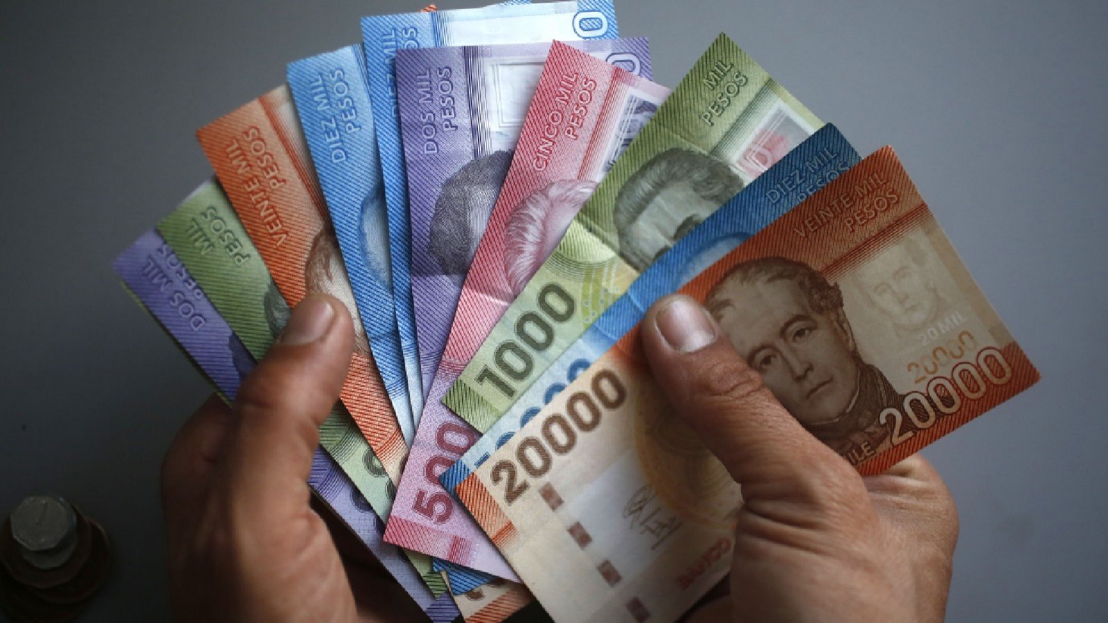 Imagen referencial de una persona contando billetes chilenos