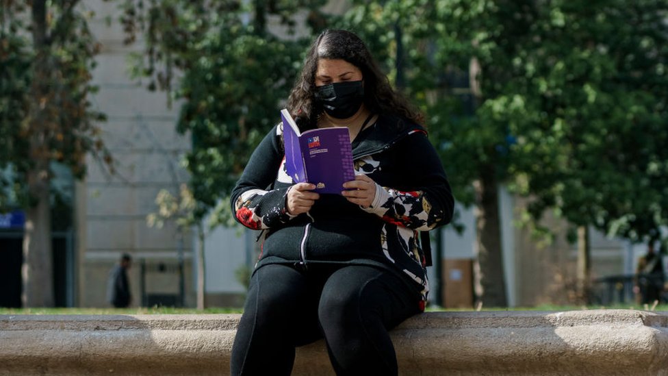 Una mujer lee un ejemplar de la nueva Constitución de Chile