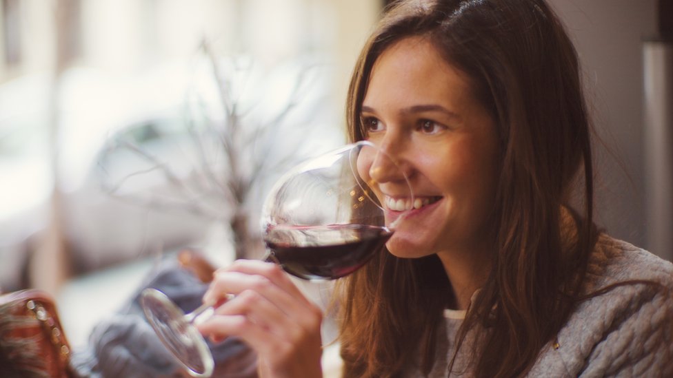 mujer tomando vino