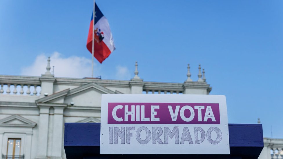 Cartel que dice "Chile vota informado" con una bandera de Chile