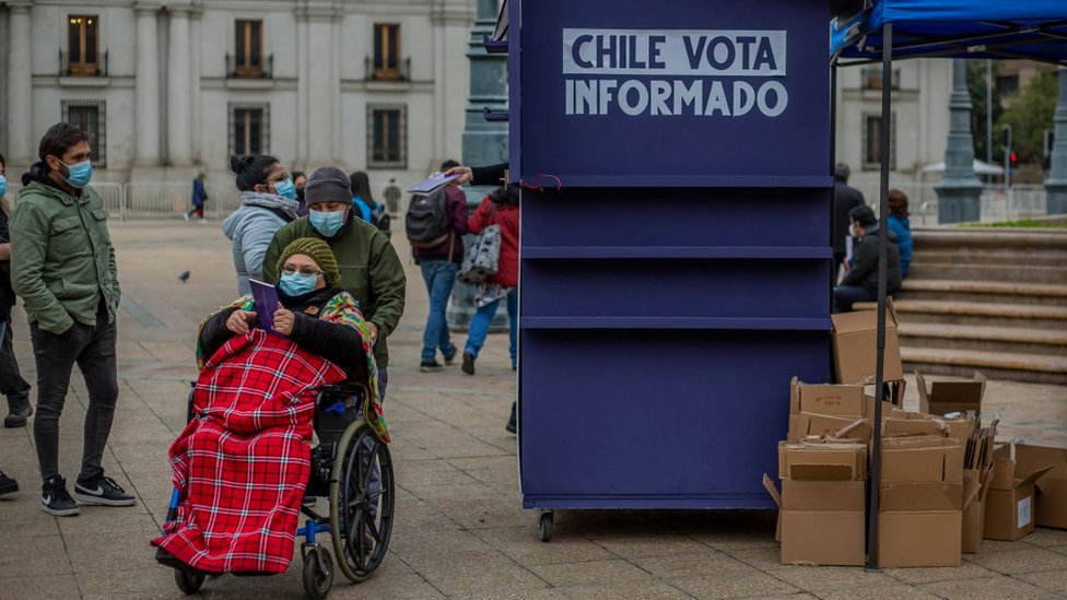 Un puesto de información sobre la Constitución en la calle, con una persona en silla de ruedas al lado