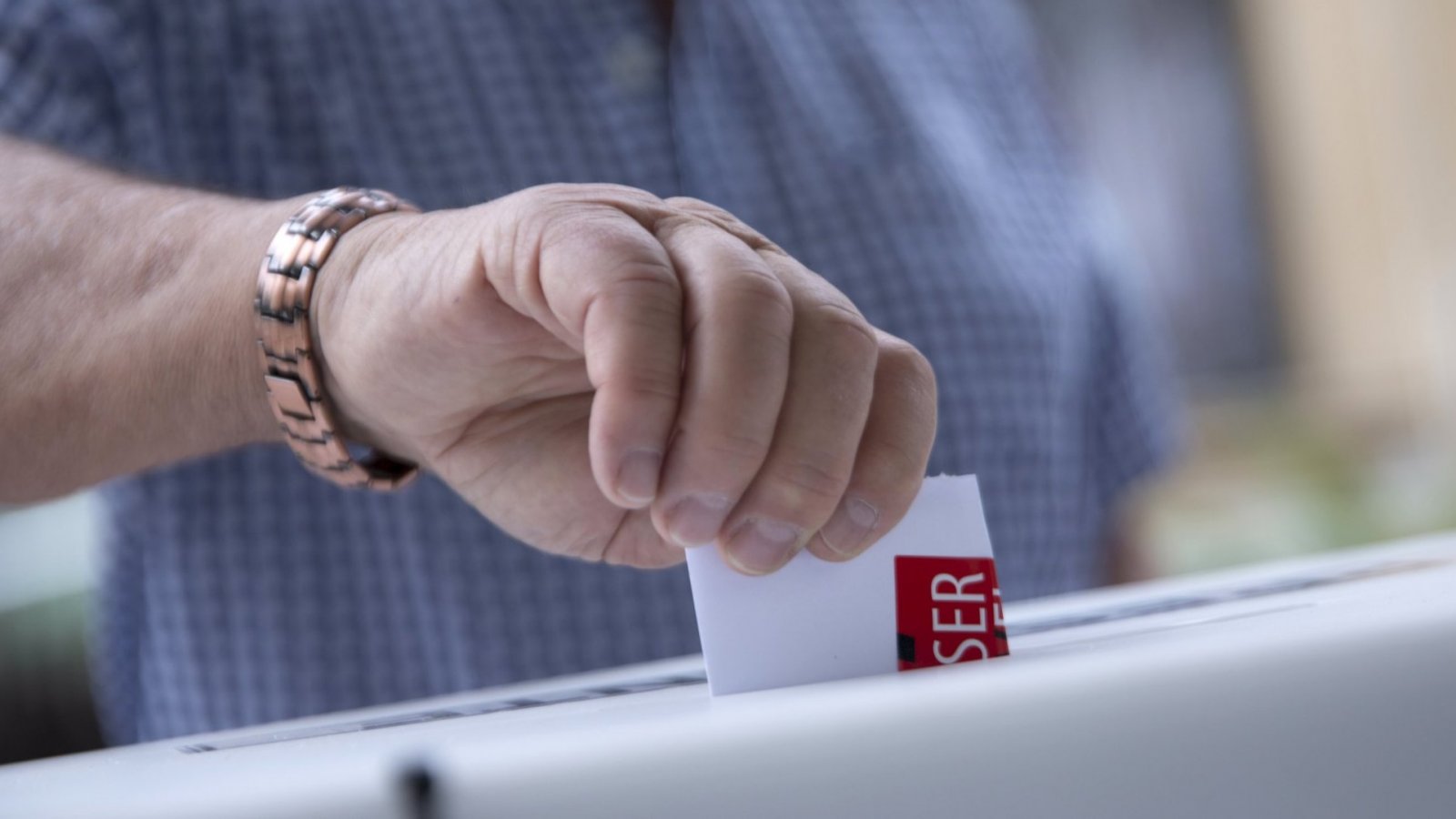 Una persona ingresando su voto en la urna