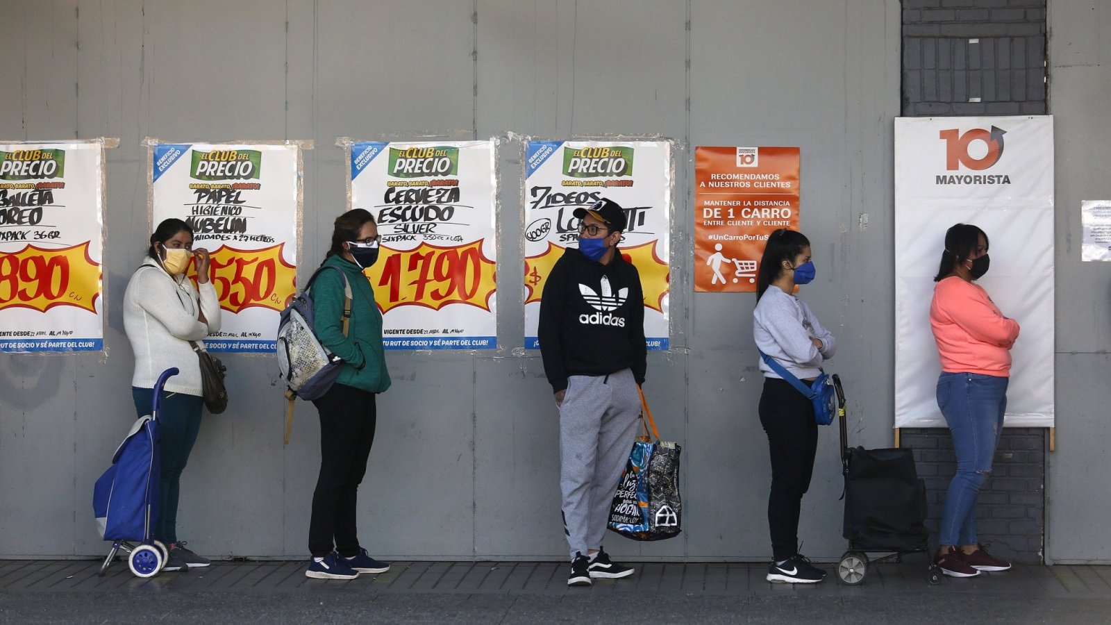 Personas haciendo filas para entrar a un supermercado