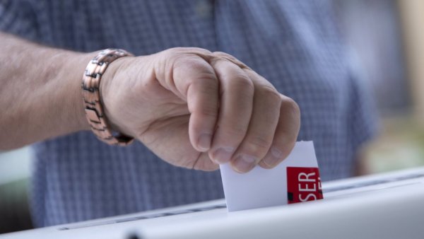 Una persona ingresando su voto en la urna