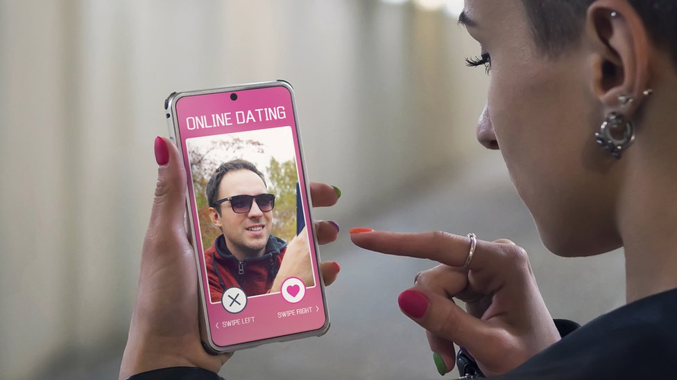 Una mujer observa en su teléfono una app de citas.