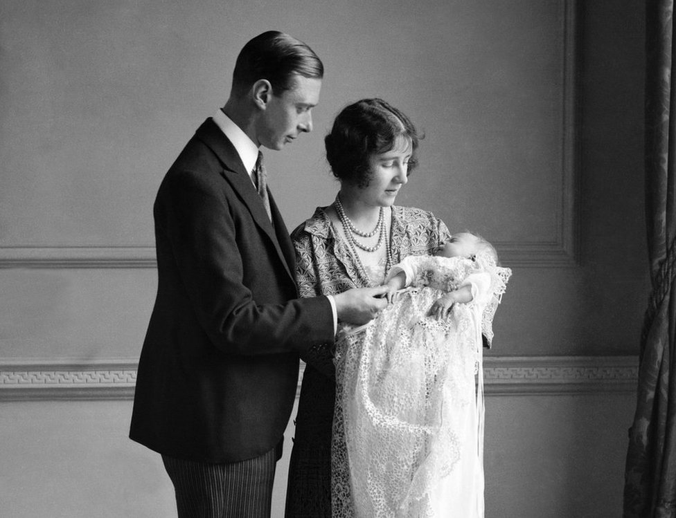 La reina madre (entonces duquesa de York) con su esposo, el rey Jorge VI (en ese momento duque de York) y su hija, la reina Isabel II (allí Isabel Alexandra Mary Windsor) en su bautismo en mayo de 1926.