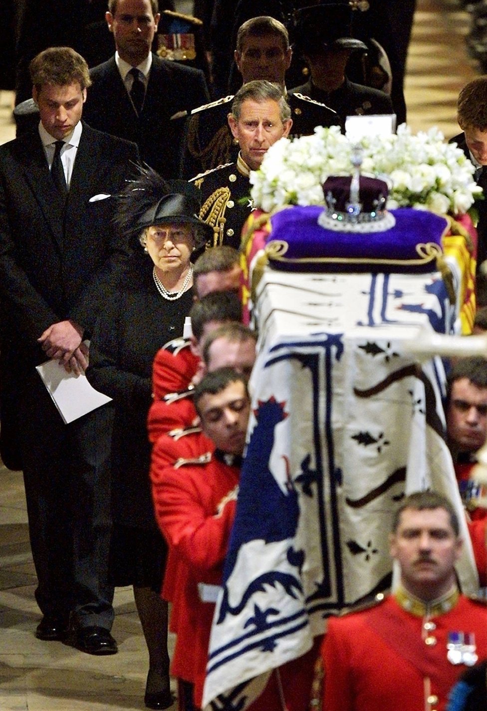 La reina Isabel II (frente) conduce a su familia mientras sigue a los portadores del féretro que llevan el ataúd de la reina Isabel, la reina madre, fuera de la Abadía de Westminster después del funeral en Londres el 09 de abril de 2002.