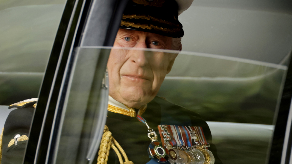 Primer plano de Carlos III dentro del coche donde se dirige al funeral de Isabel II