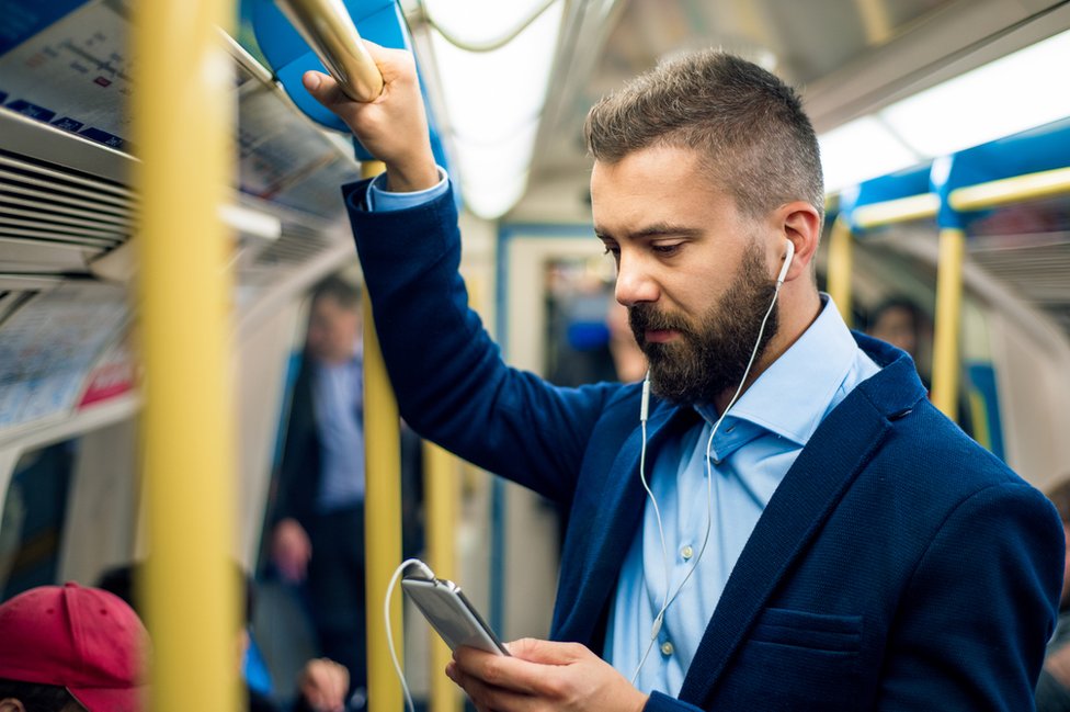 Un hombre viajando en Metro a su oficina.