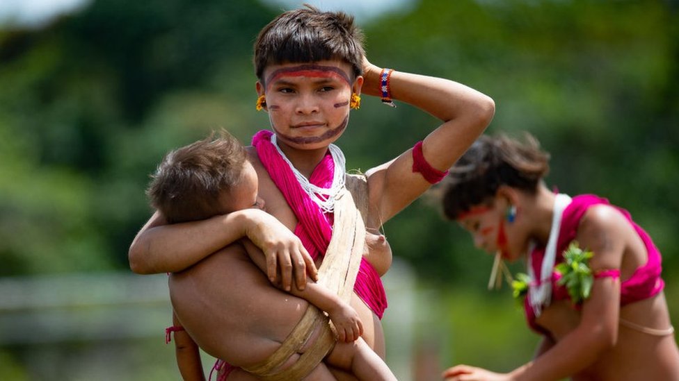 Mujer de la etnia indígena yanomami con un niño en los brazos.