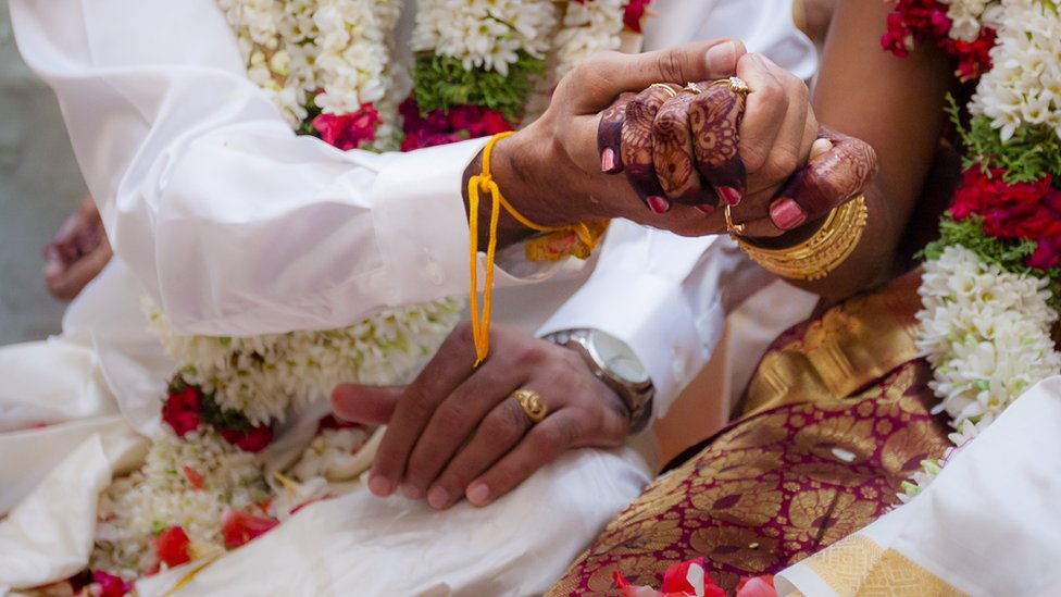 Manos de hombre y mujer de origen indio en una boda.