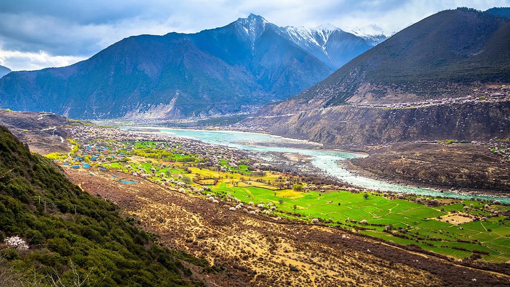 Valle entre montañas con río y pueblo