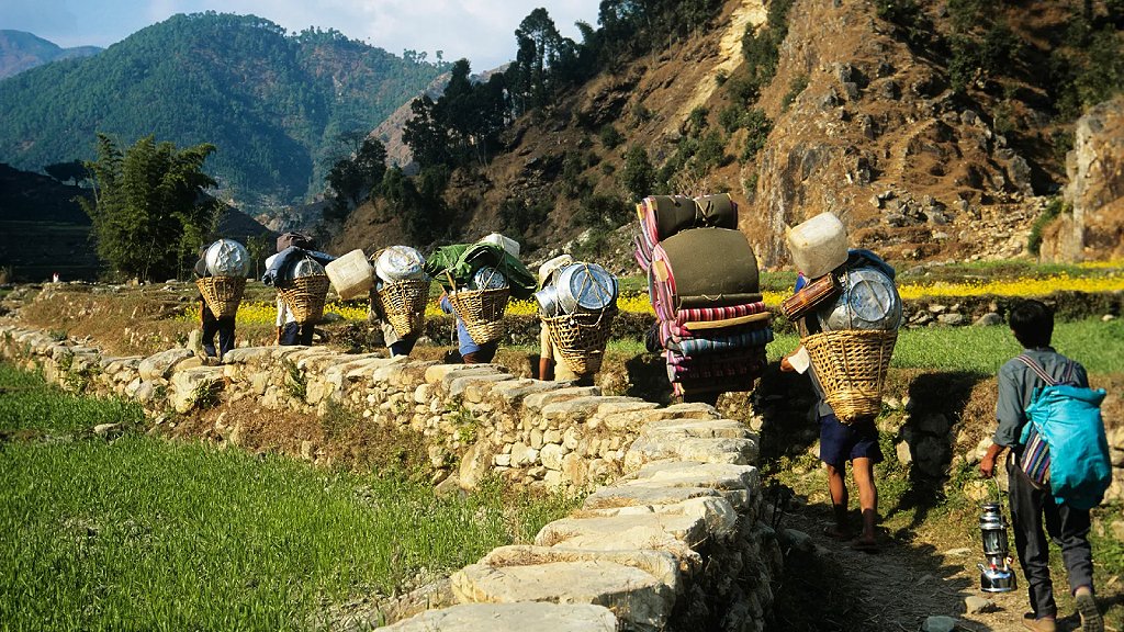 Sherpa caminando cargados con mochilas