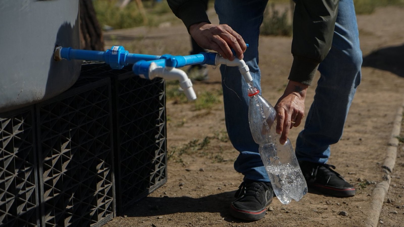 Persona recopilando agua desde un punto de abastecimiento