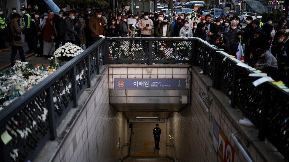 Gente cerca de la estación de metro de Itaewon llena de flores