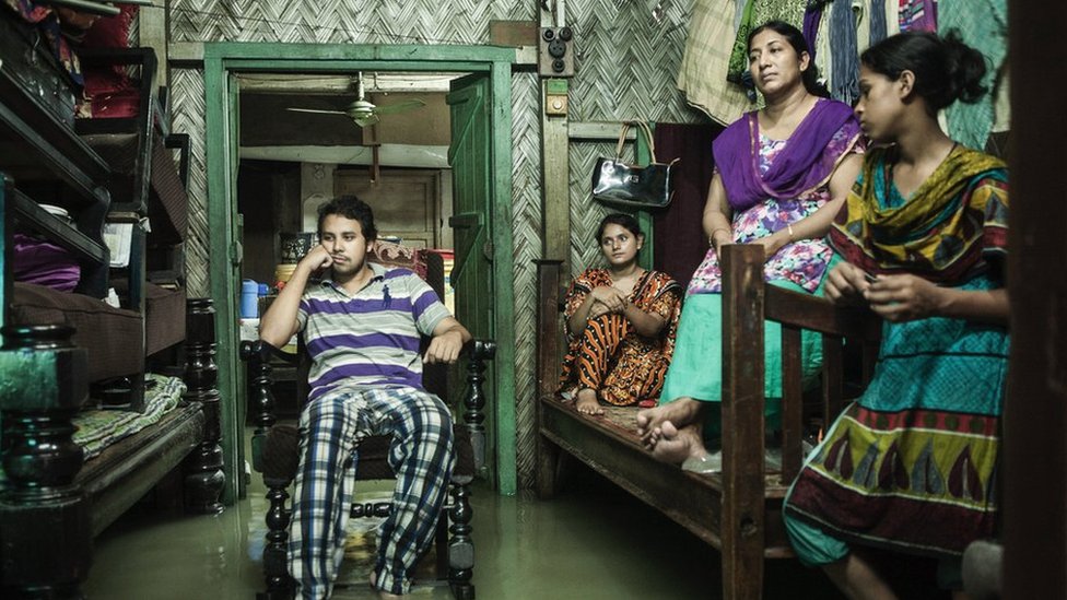 Una imagen de Jashim Salam muestra a una familia en una habitación inundada de su casa en el barrio de Chaktai.