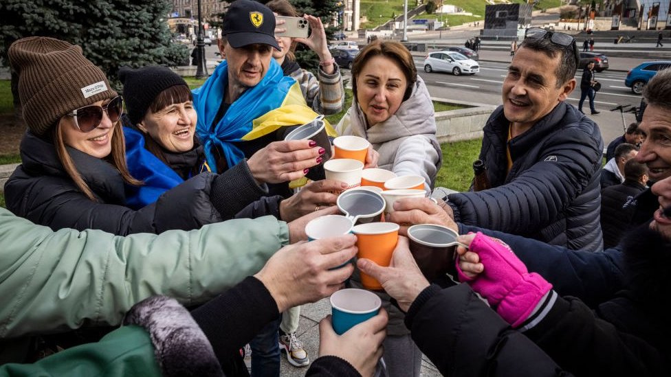 Ucranianos celebran en Kyiv brindando con vino espumoso.