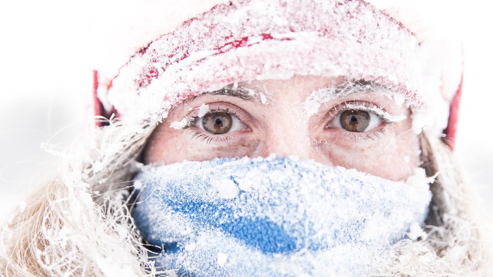 Mujer con frío en la nieve