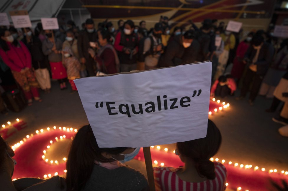 Mujeres y niños de "Maiti Nepal", un centro de rehabilitación y orfanato para afectados por el VIH sostienen un cartel que reclama "igualdad" en Katmandú, Nepal, el 30 de noviembre de 2022.