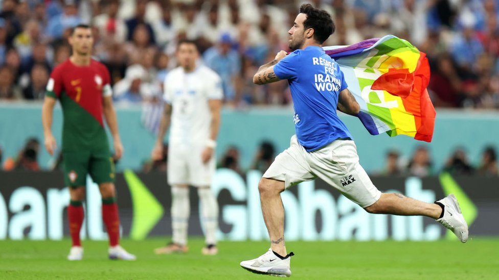 Un activista con una bandera LGBTI en el partido Portugal vs. Uruguay.