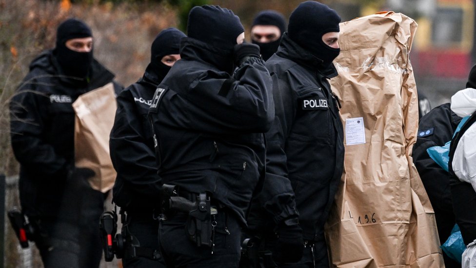 Policía alemana con objetos incautados en la redada