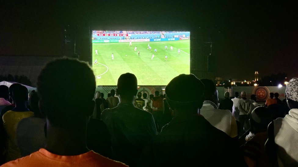 Migrantes miran el partido entre Uruguay y Ghana.