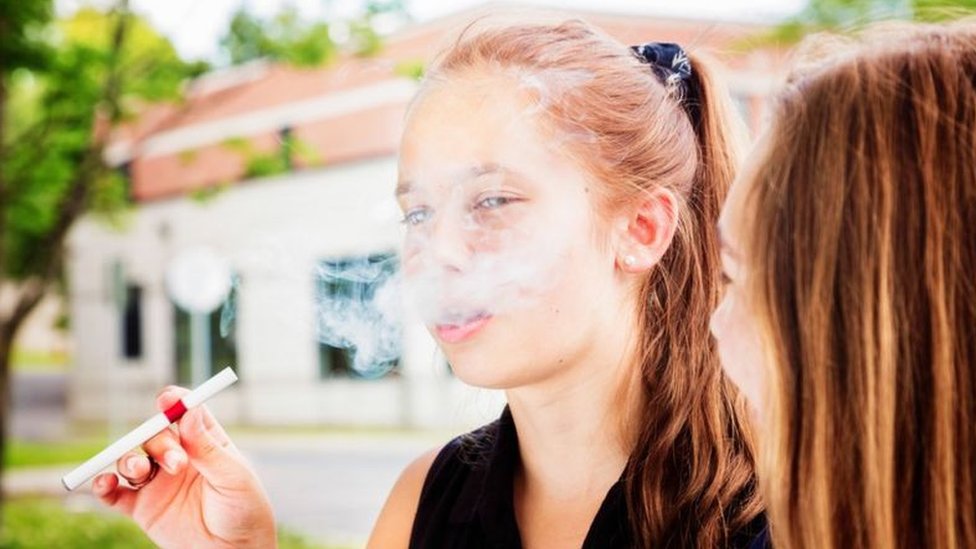 Adolescente con un cigarrillo electrónico