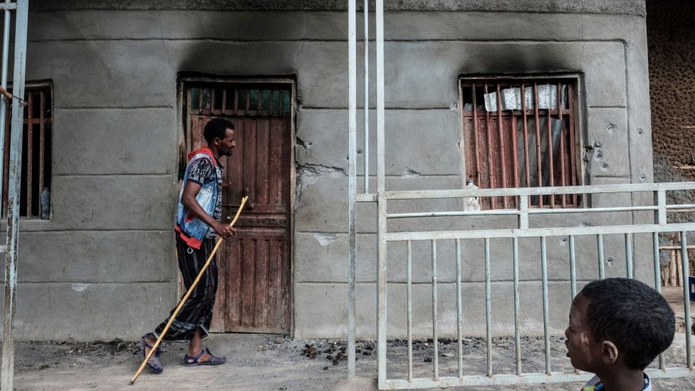 Un hombre pasa por una casa atacada en Tigray