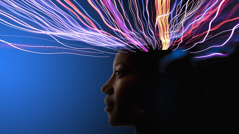 Rayos de colores saliendo de la cabeza de una mujer