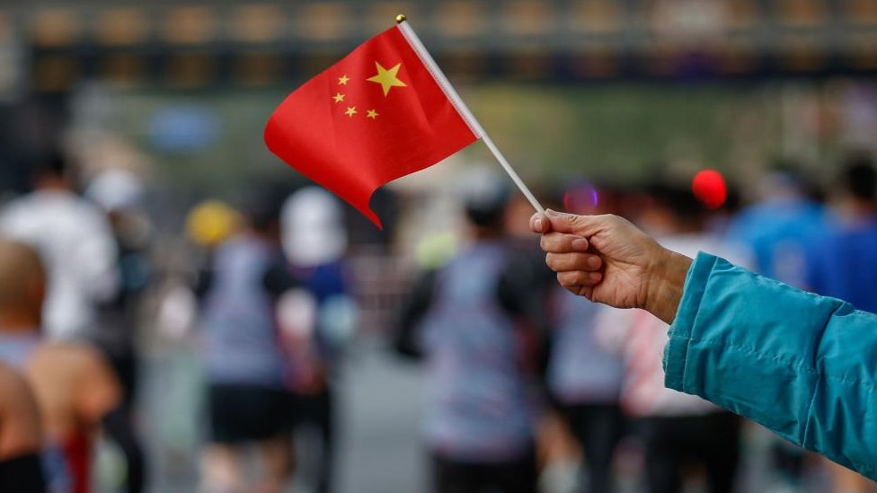A Chinese national flag is waved at an event in Beijing