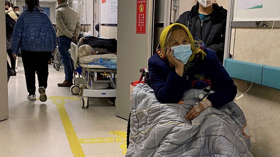 Un paciente con covid-19 espera en un pasillo de un hospital en la ciudad nororiental china de Tangshan.