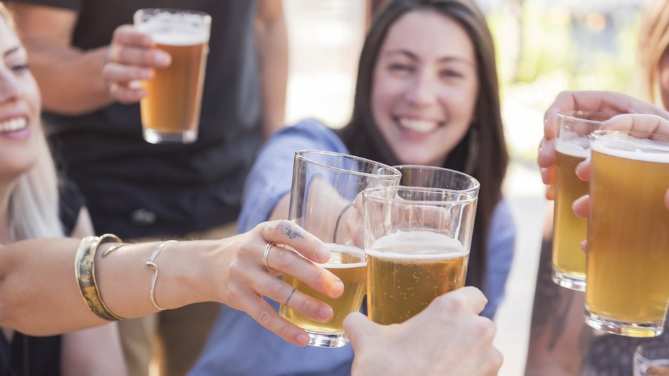 Brindis de mujeres con cerveza.