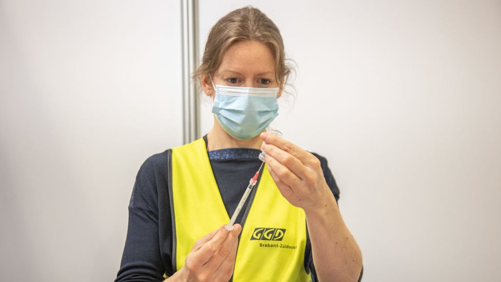 Mujer alista una dosis de la vacuna ARNm de Moderna en Países Bajos.